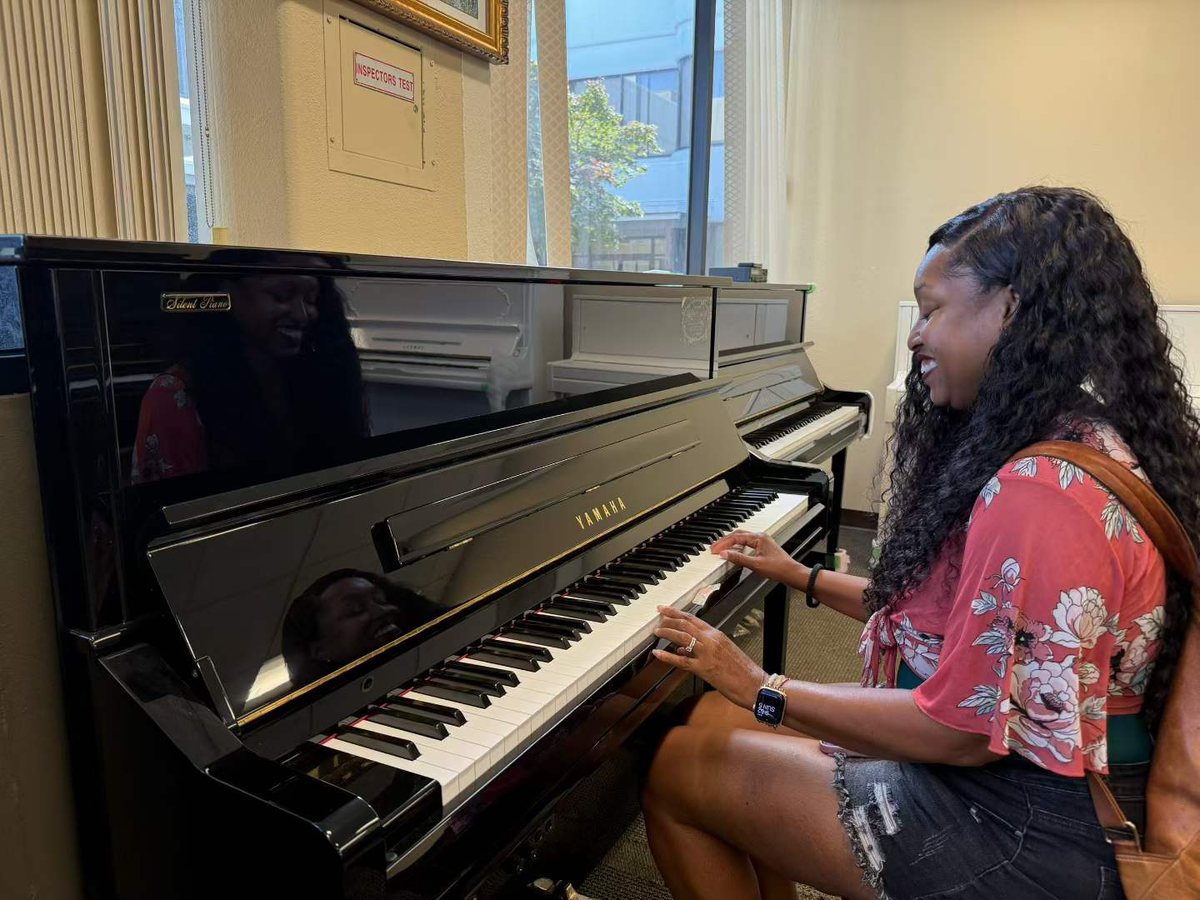 A customer trying a Yamaha silent upright piano
