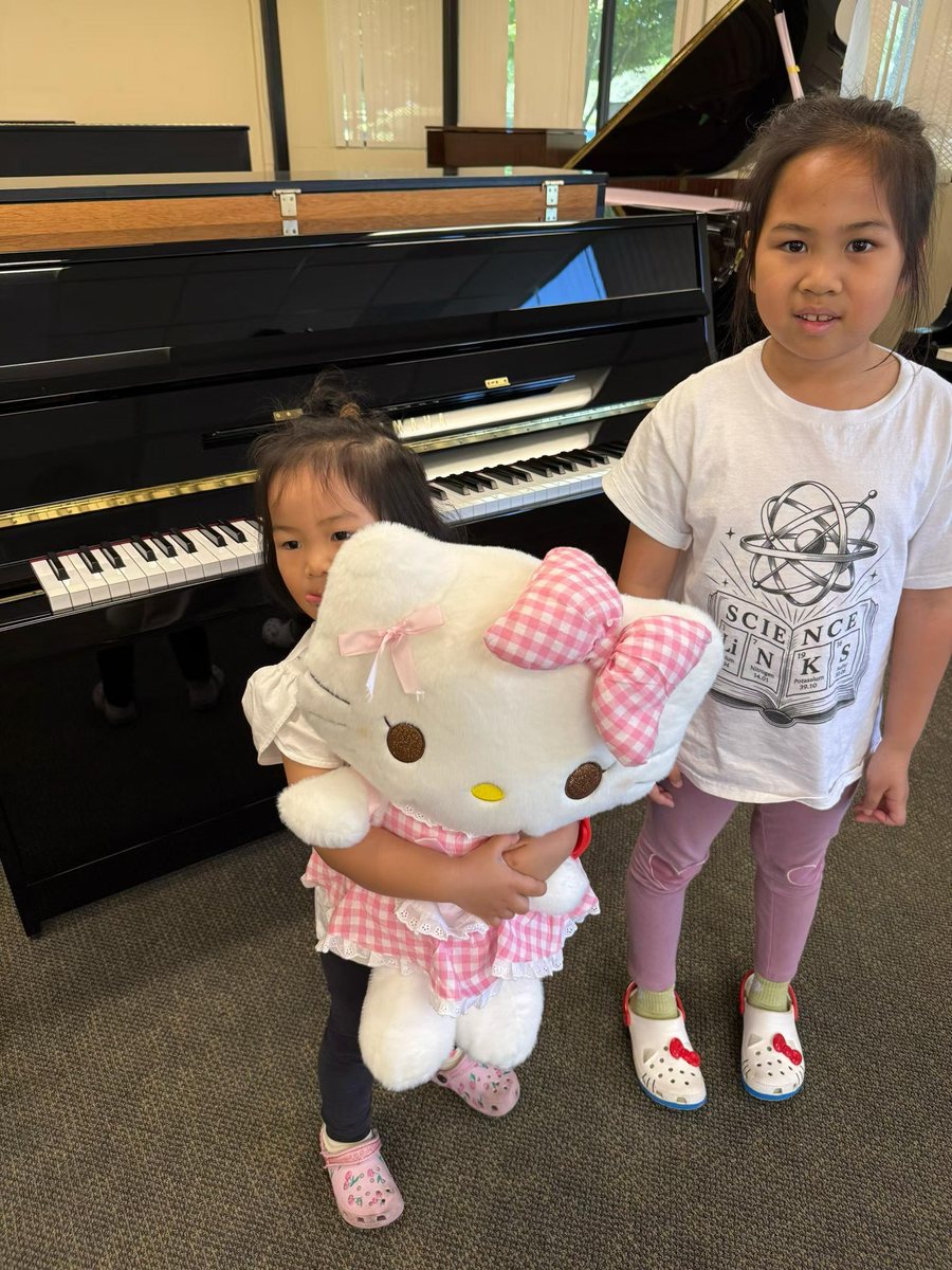 Two young sisters with their new upright piano